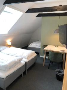 a room with two beds and a table and a desk at Go Sleep Vandel in Vandel