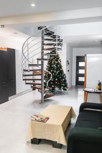 un arbre de Noël dans un salon avec un escalier en colimaçon dans l'établissement Privilege Suite, à Tal-Pietà