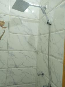 a shower with a white marble wall and a shower head at Nubian Queen Guest House in Aswan