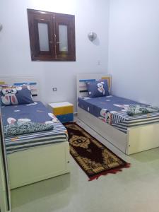 a bedroom with two beds and a mirror at Nubian Queen Guest House in Aswan