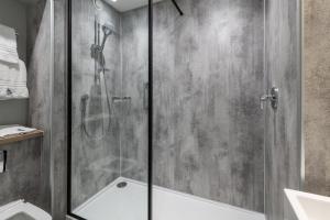a shower with a glass door in a bathroom at Royal National Hotel in London