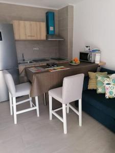 kuchnia ze stołem, 2 krzesłami i blatem w obiekcie Quiet & Bright Apartment with private garden w mieście Maspalomas