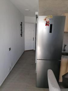 kuchnia z lodówką ze stali nierdzewnej w pokoju w obiekcie Quiet & Bright Apartment with private garden w mieście Maspalomas