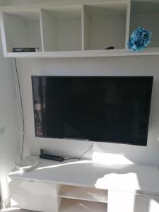 telewizor z płaskim ekranem na białej ścianie w obiekcie Quiet & Bright Apartment with private garden w mieście Maspalomas