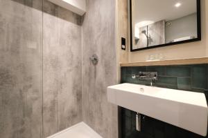 uma casa de banho com um lavatório e um espelho em Royal National Hotel em Londres