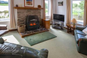 ein Wohnzimmer mit Kamin und Couch in der Unterkunft Lochside Cottage - near Aviemore in Aviemore