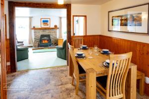 ein Esszimmer mit Tisch und Kamin in der Unterkunft Lochside Cottage - near Aviemore in Aviemore