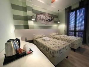 ピアチェンツァにあるResidence Europaのベッド2台とテーブルが備わるホテルルームです。