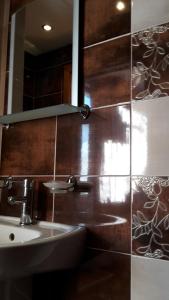 een badkamer met een wastafel en een spiegel bij Kyurkchievi Guest House in Sapareva Banya