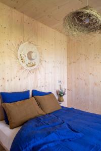 Schlafzimmer mit einem Bett mit blauer Bettwäsche und Holzwänden in der Unterkunft Casa Ladoit - maison d'architecte vue sur vignes in Mercurey