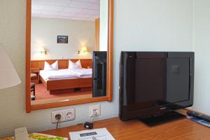 フライブルクにあるHotel Rebschuleのホテルの部屋のデスクに座ってテレビを見ることができます。