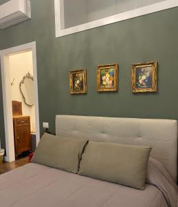 a living room with a couch and four paintings on the wall at Ortigia Twin Rooms in Siracusa