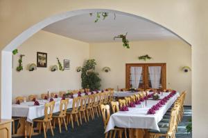 a banquet hall with tables and chairs with flowers on them at Hotel Rebschule in Freyburg