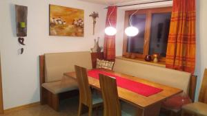 une salle à manger avec une table en bois et une fenêtre dans l'établissement Loretz Luzia, à Silbertal