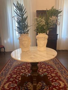 two vases sitting on a table with flowers on it at Ortigia Twin Rooms in Siracusa