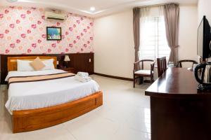 una camera d'albergo con letto, scrivania di LUXURY HOTEL HẬU GIANG ad Ho Chi Minh