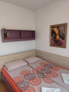 a bedroom with a bed with a painting on the wall at Apartment Budapeshta in Sofia