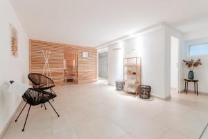 ein Wohnzimmer mit einem schwarzen Stuhl und weißen Wänden in der Unterkunft Granetal.Quartier in Hahnenklee-Bockswiese