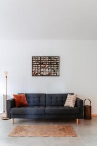 uma sala de estar com um sofá azul em frente a uma parede branca em Granetal.Quartier em Hahnenklee-Bockswiese