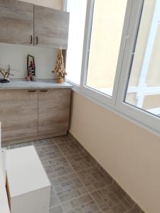 a kitchen with wooden cabinets and a window at Апартамент "Рая" in Dobrich +24 photos