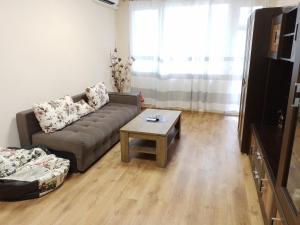 a living room with a couch and a coffee table at Апартамент "Рая" in Dobrich