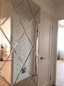 a glass door in a room with a brick wall at 1-комнатная квартира in Kokshetau
