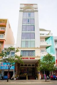 un alto edificio bianco con torre dell'orologio di LUXURY HOTEL HẬU GIANG ad Ho Chi Minh