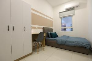 um quarto com uma cama, uma secretária e uma janela em Spacious 3-bedroom condo for 5 Pax @ Titiwangsa Sentral KL em Kuala Lumpur