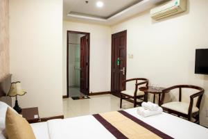 una camera d'albergo con due letti e un tavolo con sedie di LUXURY HOTEL HẬU GIANG ad Ho Chi Minh