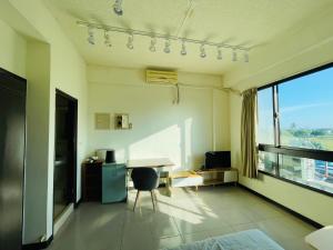ein Bürozimmer mit einem Schreibtisch und einem Fenster in der Unterkunft American Style Rende in Tainan