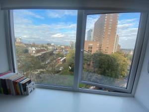 a window with a view of a city at 1+1 Modern flat next to Sutton train station in Sutton