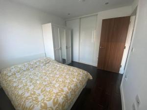 a bedroom with a bed and a wooden cabinet at 1+1 Modern flat next to Sutton train station in Sutton