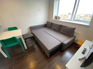 a living room with a couch and a table and a desk at 1+1 Modern flat next to Sutton train station in Sutton
