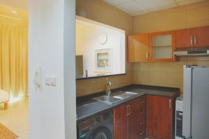 a kitchen with a sink and a refrigerator at Calm&Cozy1BR- Dubai Silicon Oasis-15min-Dxb airpt in Dubai