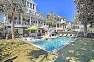 a large house with a swimming pool in the yard at Luxury Modern Home- Steps 2 Beach, Private Pool/Bar, Sleeps 16, 7 BD-5.5 BR- 'The Lucky Penny' in Isle of Palms