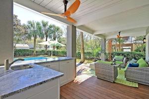 a kitchen with a ceiling fan and a patio at Luxury Modern Home- Steps 2 Beach, Private Pool/Bar, Sleeps 16, 7 BD-5.5 BR- 'The Lucky Penny' in Isle of Palms