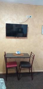 a table with two chairs and a tv on a wall at Apartment Matkovic in Tivat