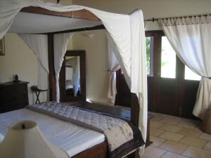 a bedroom with a canopy bed in a room at Bartholomew Villas in Saint Georgeʼs