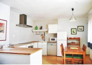 eine Küche mit einem Holztisch und einem weißen Kühlschrank in der Unterkunft Casa La Reja in Rodalquilar