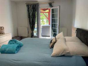 a bedroom with a bed with pillows and a window at Magnifique Villa avec Piscine-Jacuzzi-coin fitness in Bidart +35 photos