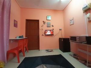 a room with a door and a tv on a wall at GUESTHOUSE MOKTEH in Kuala Terengganu
