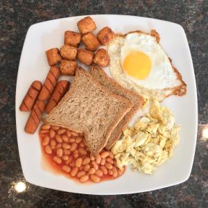 un plato de desayuno con huevos, pan y judías en Grand Elephant Mirissa en Mirissa