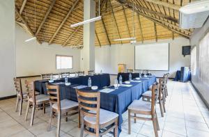 Nongoma Lodge & Inn CC في Nongoma: غرفة كبيرة مع طاولة وكراسي طويلة