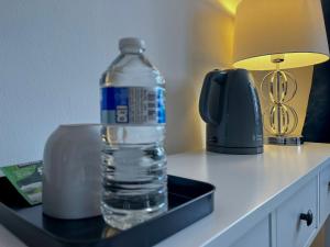 a bottle of water sitting on a table next to a lamp at Maberic Housing in Cranford