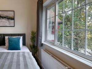a bedroom with a bed and a large window at Maberic Housing in Cranford