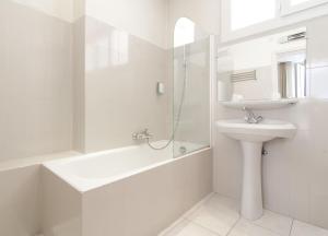 a white bathroom with a sink and a shower at Hôtel P.L.M. in Cannes