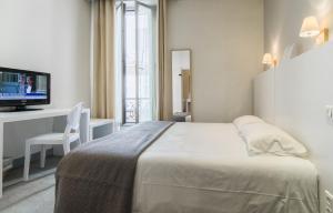 a hotel room with a bed and a television at Hôtel P.L.M. in Cannes