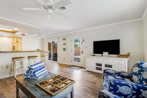 a living room with a tv and a couch and a table at Beach Villa 1B in Holmes Beach