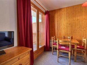 a dining room with a table and a television at Studio cosy 4 pers. au pied des pistes avec balcon - FR-1-455-112 in Plagne 1800 +2 photos