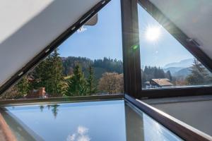 an open window with a view of the mountains at Clăbucet Luxury Apartament in Predeal